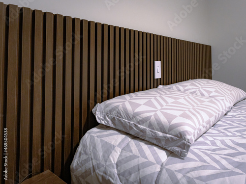 detail of pillows and headboard in slatted dark wood