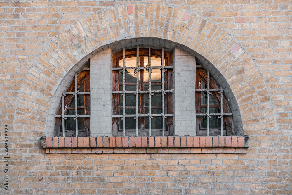 Wooden arch window of medieval fortress with iron protection grate. Old. History. Architecture. Brick wall Wooden arch window of medieval fortress with iron protection grate. Old. History. Architecture. Brick wall
