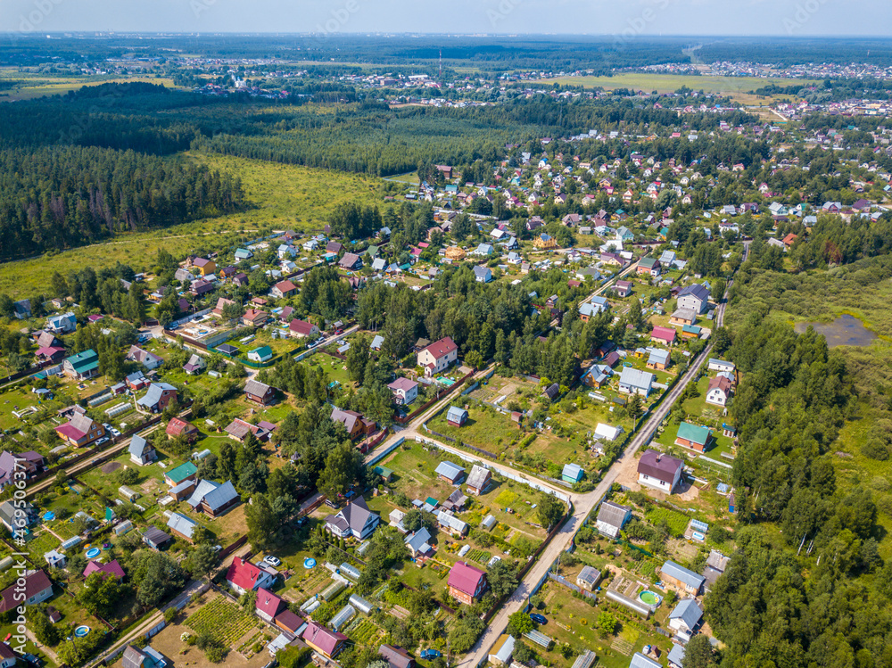 Top drone panorama view of of private sector of city. Modern european architecture. Green forest in sunset light. general plan