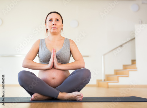 pregnant woman is engaged in yoga. Easy pose or Sukhasana.