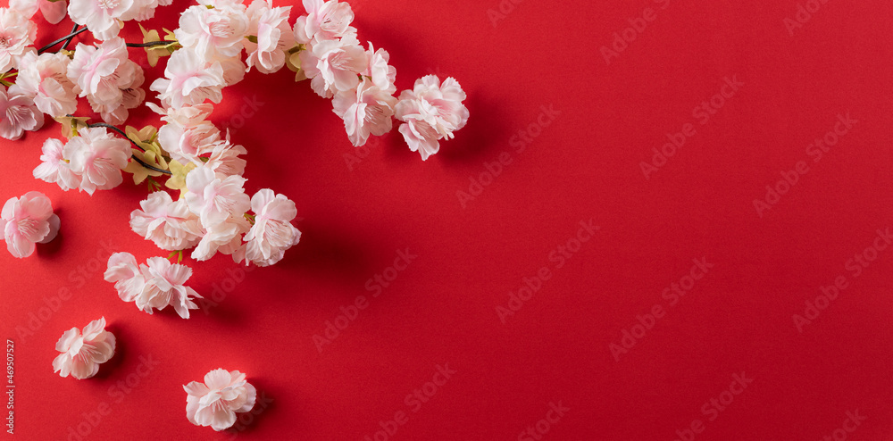 Chinese new year festival decorations made from plum blossom on red background. Flat lay, top view with copy space.