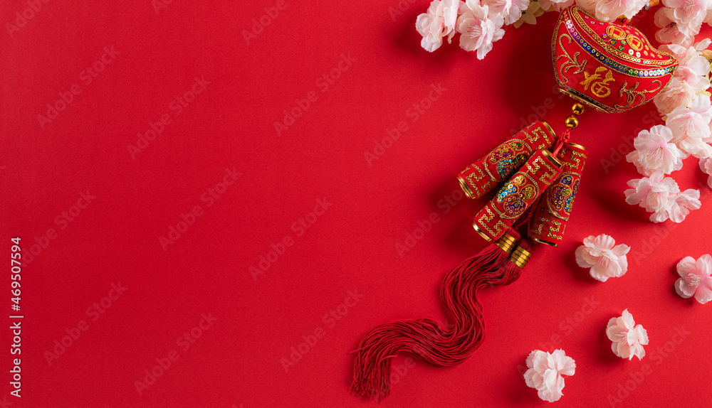 Chinese new year festival decorations made from chinese good luck symbol and plum blossom on a red background. Flat lay, top view with space.