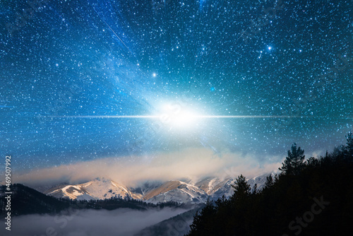 Fantasy night scene, starry sky over the clouds and mountains.