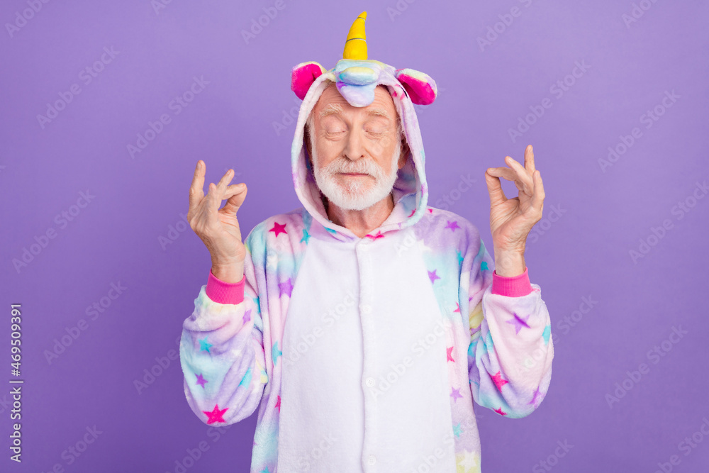 Portrait of attractive dreamy calm grey-haired man wearing kigurumi meditating isolated over violet purple color background Portrait of attractive dreamy calm grey-haired man wearing kigurumi meditating isolated over violet purple color background