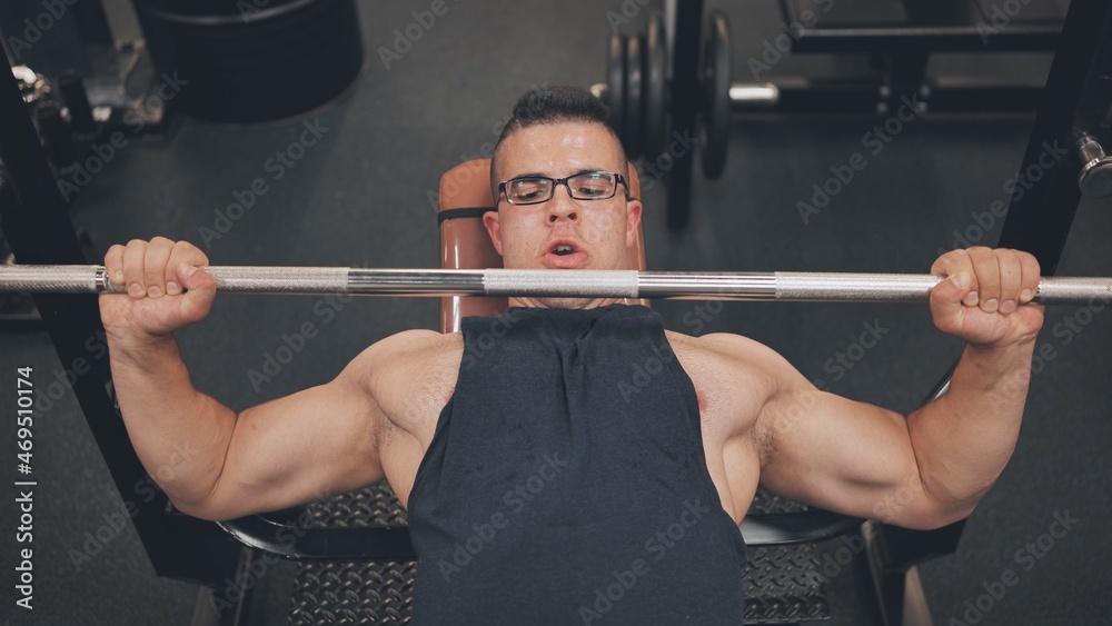 An Arab man pumps his chest in the gym.