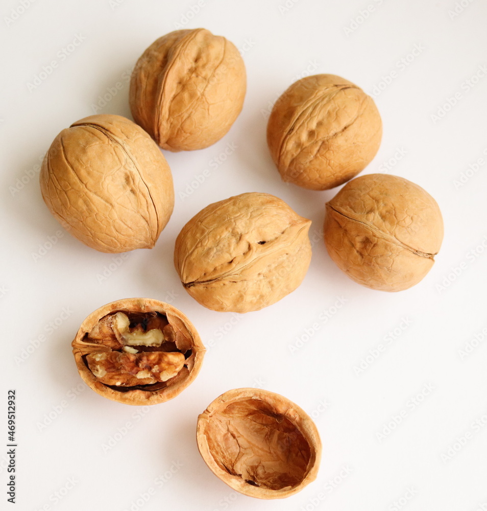 Walnuts. Shelled and unshelled walnuts isolated on white background, on table. Macro, close up, top view. Walnuts. Shelled and unshelled walnuts isolated on white background, on table. Macro, close up, top view.