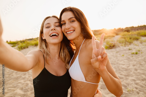 Young white women smiling and gesturing while taking selfie photo