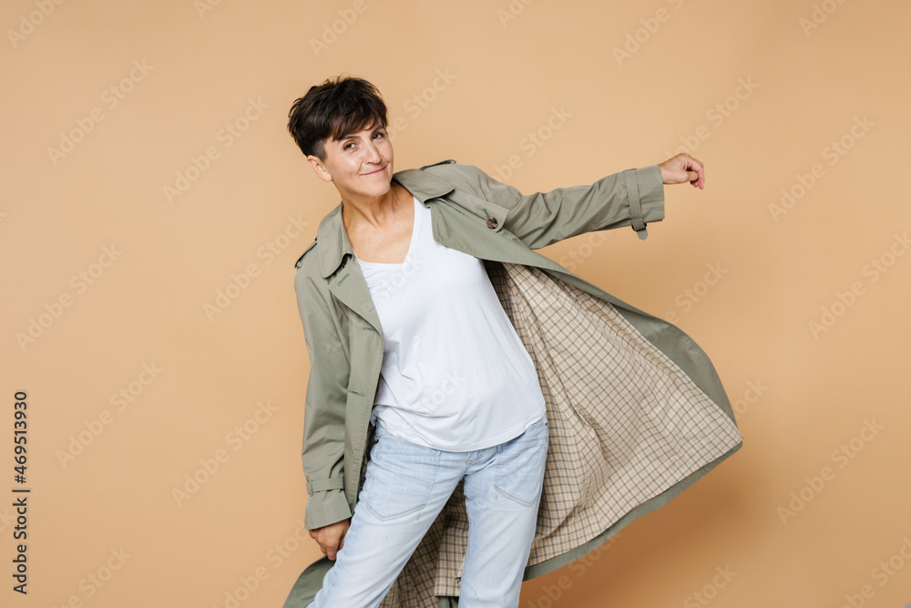 Mature european woman smiling while posing in coat Mature european woman smiling while posing in coat