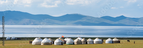 Yurts by the Shores of Issyk-Kul Lake.
Traditional yurts dot the shores of Issyk-Kul Lake, set against a backdrop of distant mountains and calm blue waters