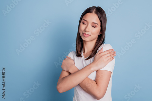 Photo of lovely inspired lady embrace shoulders close eyes dream love herself on blue background