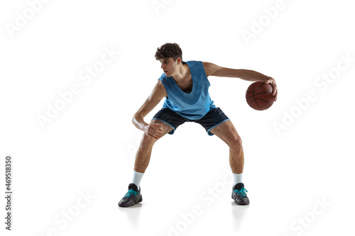 Dynamic portrait of basketball player practicing isolated on white studio background. Sport, motion, activity, movement concepts. © master1305