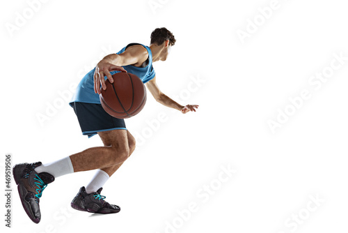 One professional basketball player in blue sports uniform training with ball isolated on white studio background. © master1305