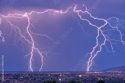 Lightning bolts striking Prescott area in the distance with the town of Chino Valley just north of Prescott Town in the foreground, Arizona