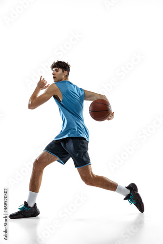 One professional basketball player in blue sports uniform training with ball isolated on white studio background.