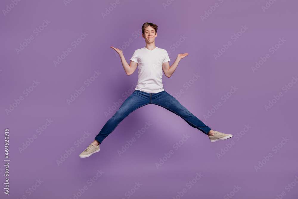 Full body photo of young man jump up show hands advertise choice isolated on violet color background