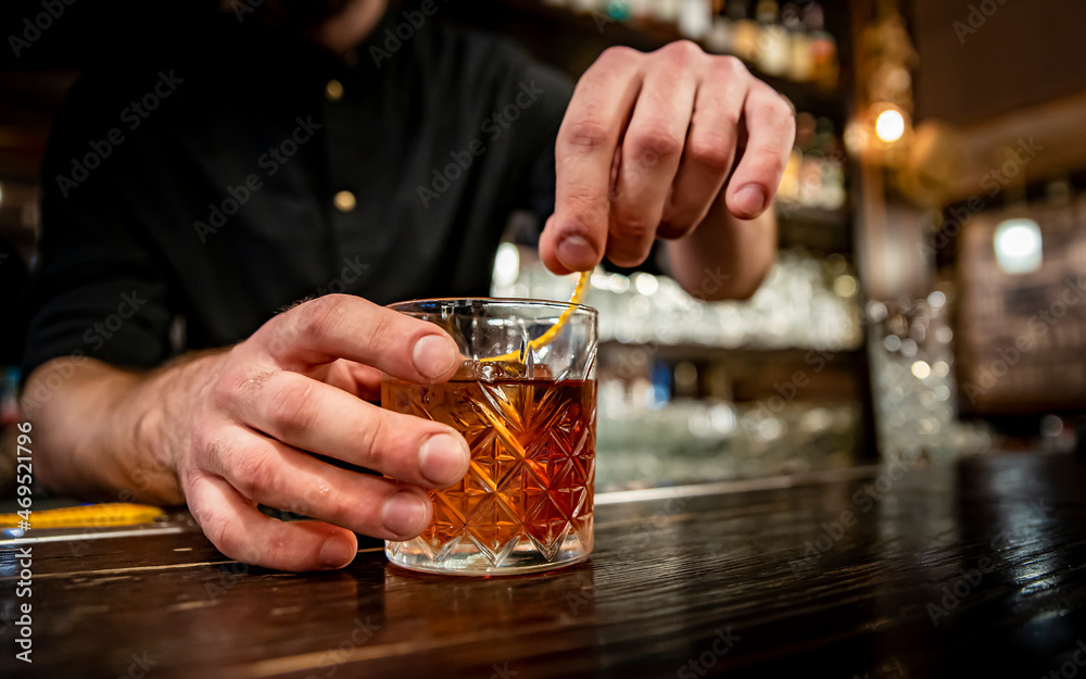 man hand bartender making negroni cocktail in bar