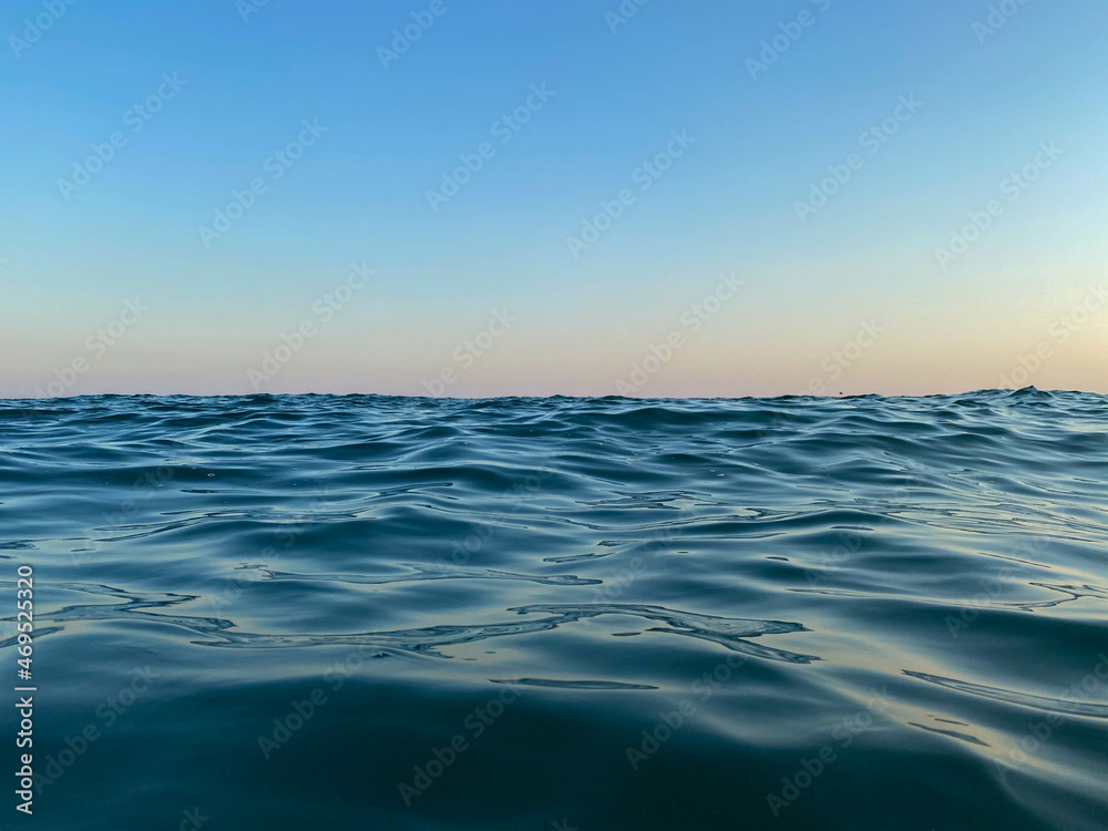 Obraz premium Blue sea at sunset, horizon, close-up, background