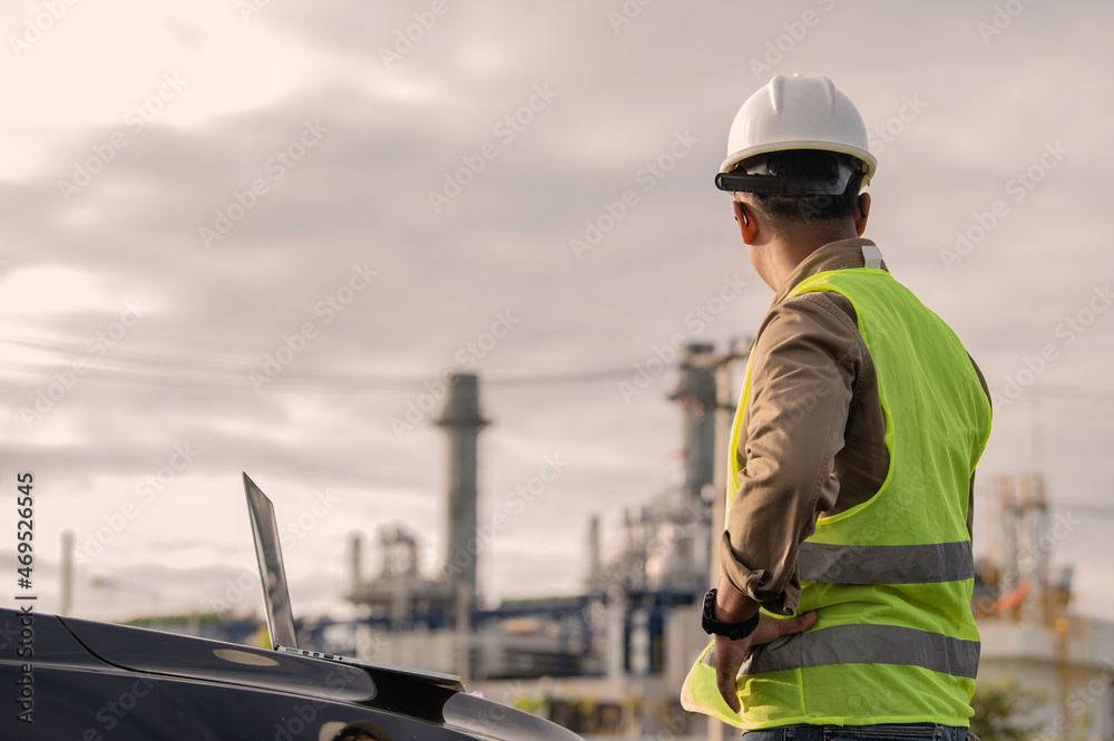 Fototapeta premium Asian man petrochemical engineer working at oil and gas refinery plant industry factory,The people worker man engineer work control at power plant energy industry manufacturing