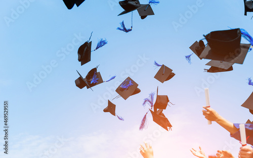 Graduating students hands throwing graduation caps in the air photo