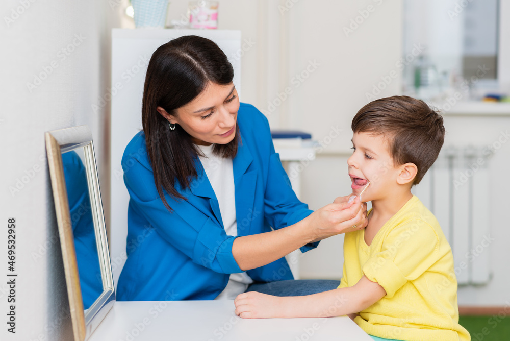 Woman speech therapist helps a child correct the violation of his speech in her office Woman speech therapist helps a child correct the violation of his speech in her office