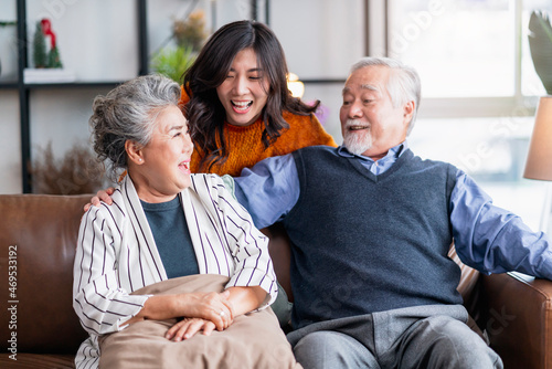 happiness asian family candid of daughter hug grandparent mother farther senior elder cozy relax on sofa couch surprise visiting in living room at home,together hug cheerful asian family at home photo