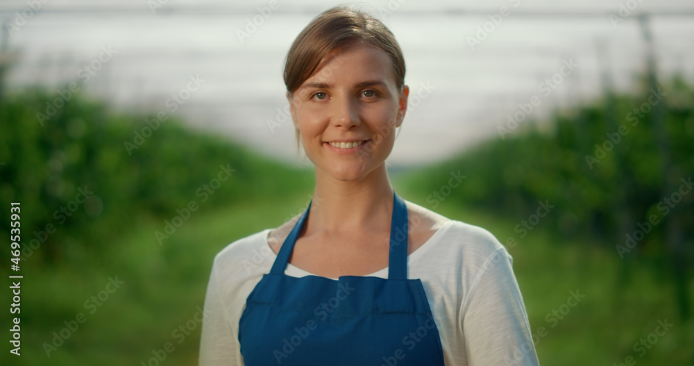Farmer professional looking camera in berry production season. Summer concept.