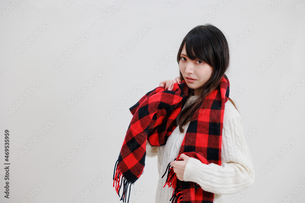 白い背景に赤いマフラーを身に着けている日本人女性