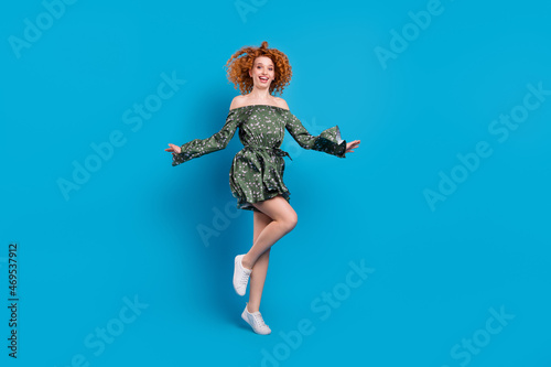 Full body photo of sporty ginger hairdo lady jump wear dress isolated on blue color background © deagreez
