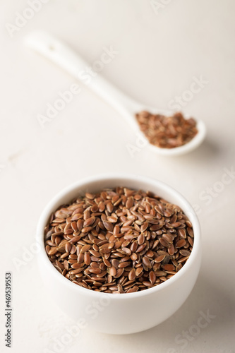 Flax seeds in a bowl on a light background. Selective focus. Close-up.