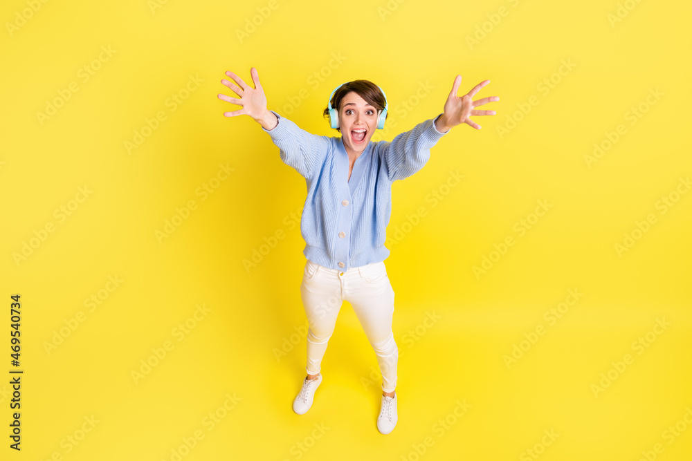 Photo of lady arm invite embrace open mouth wear earphones blue cardigan isolated yellow color background