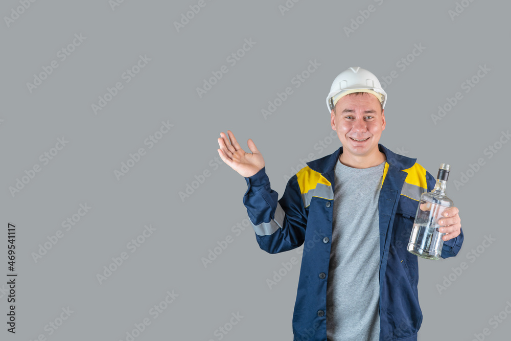 Drunk construction worker in work clothes and hardhat holds a bottle of alcohol in his hand and spreads his hands, copyspace Drunk construction worker in work clothes and hardhat holds a bottle of alcohol in his hand and spreads his hands, copyspace