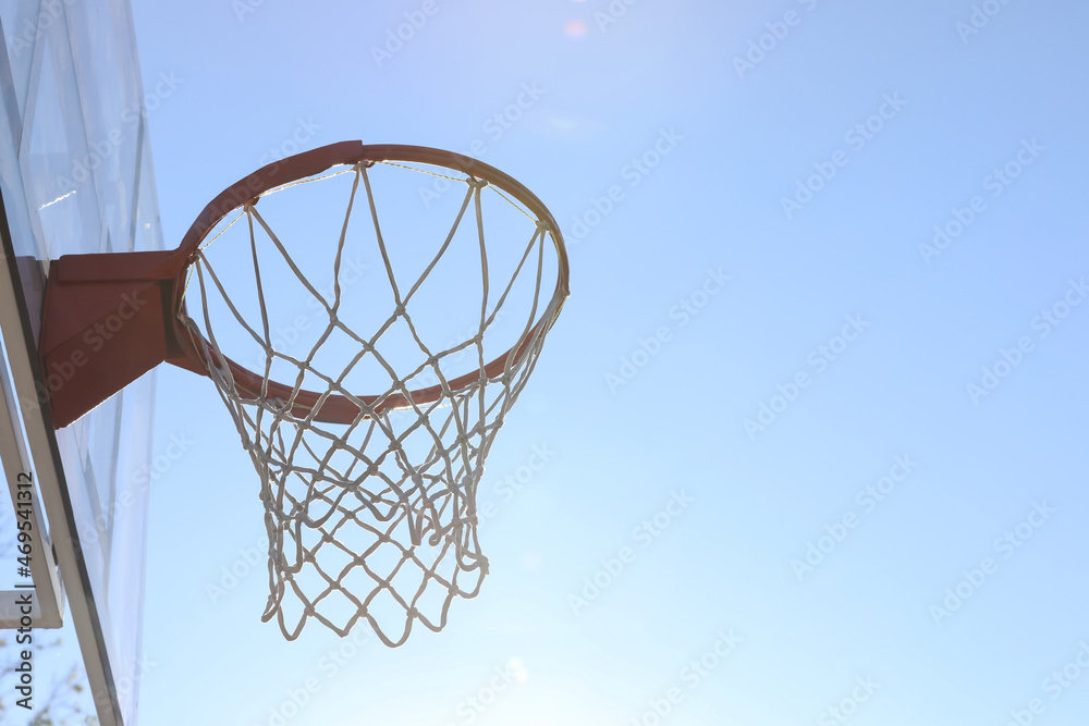 Basketball hoop with net outdoors on sunny day. Space for text
