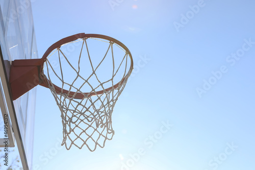 Basketball hoop with net outdoors on sunny day. Space for text