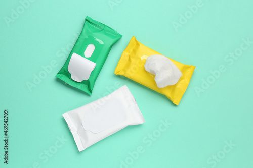 Wet wipes flow packs on turquoise background, flat lay