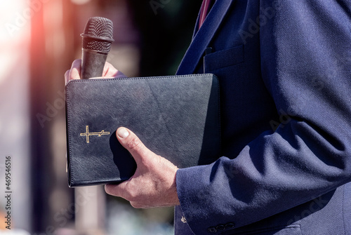 Pastor with a Bible in his hand during a sermon. The preacher delivers a speech