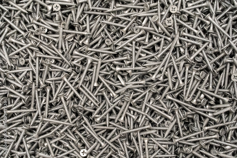 Tapping screws made of steel, metal screw, iron screw, chrome screw, screws as a background, wood screw. Background, abstraction, texture, construction