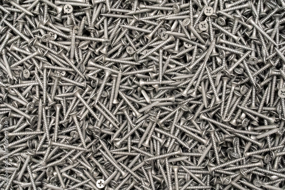 Tapping screws made of steel, metal screw, iron screw, chrome screw, screws as a background, wood screw. Background, abstraction, texture, construction Tapping screws made of steel, metal screw, iron screw, chrome screw, screws as a background, wood screw. Background, abstraction, texture, construction