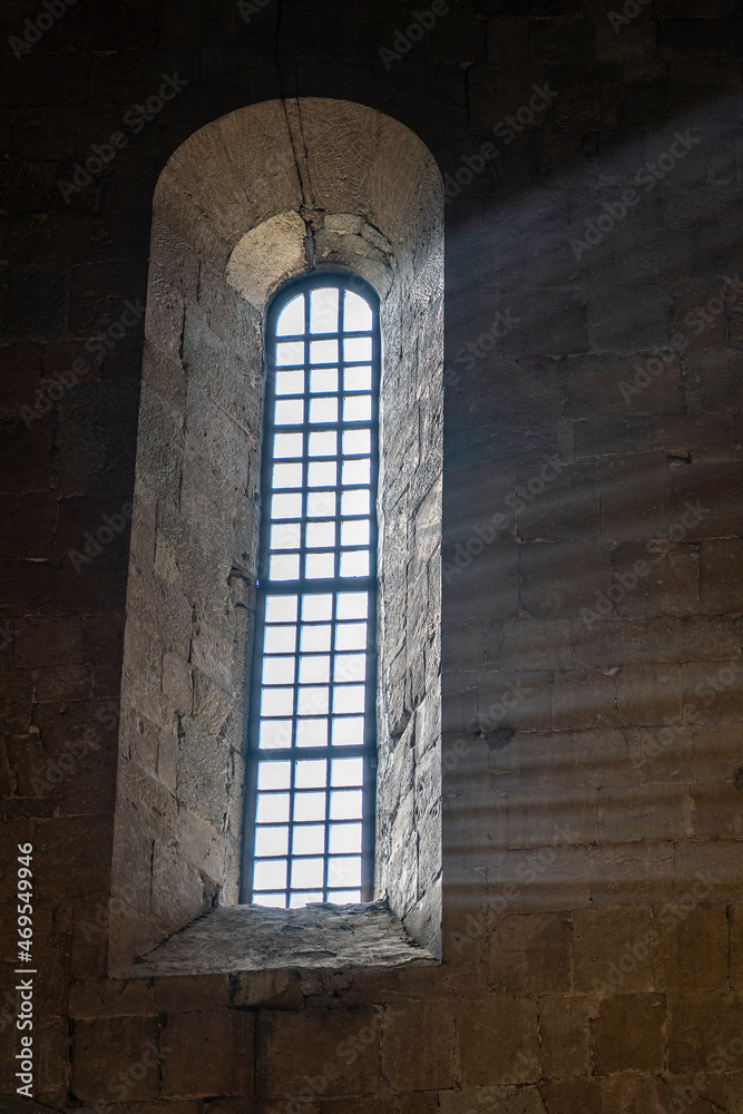 Sunlight penetrates through the arched window in the old orthodox cathedral , Georgia