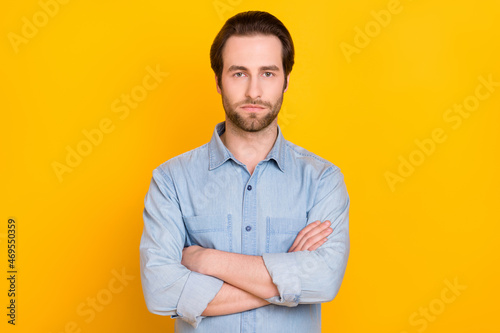 Photo portrait of young business man serious with crossed hands isolated on vibrant yellow color background
