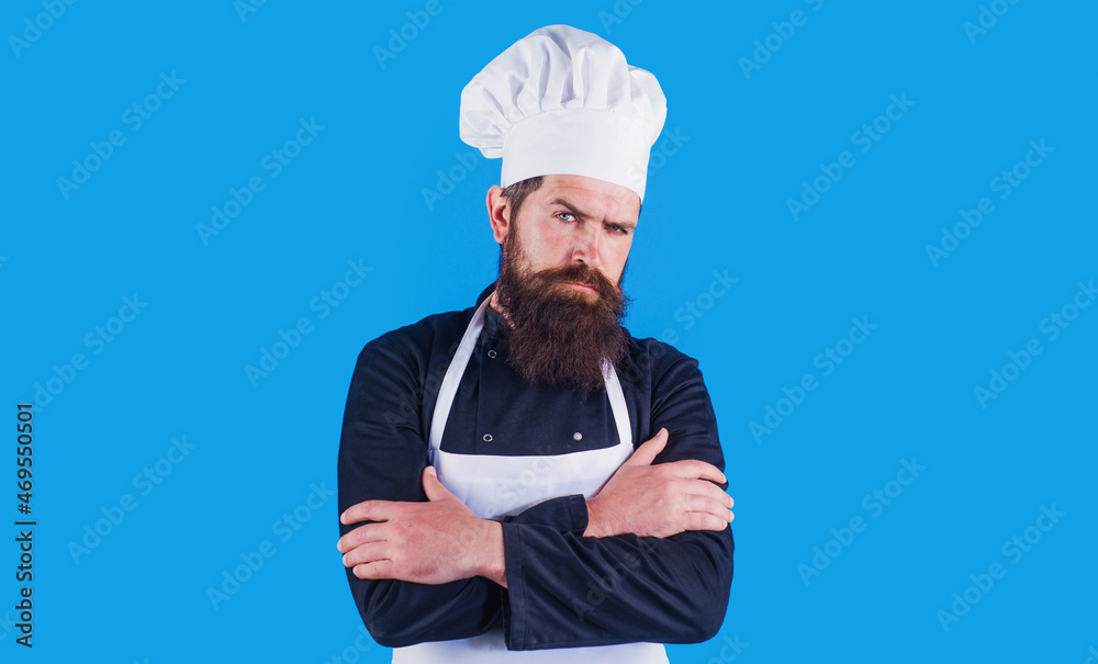 Serious bearded chef in uniform and apron with arms crossed. Cooking, profession and people concept. Serious bearded chef in uniform and apron with arms crossed. Cooking, profession and people concept.