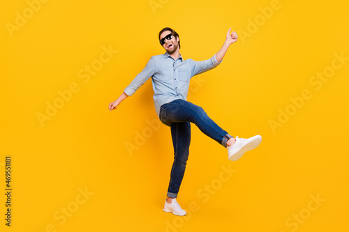 Full length photo of young excited man happy positive smile have fun enjoy party dance isolated over yellow color background