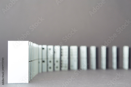 Dominoes falling in a row , gray background