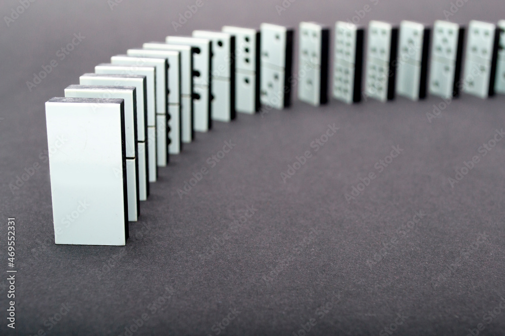 Dominoes falling in a row , gray background Dominoes falling in a row , gray background