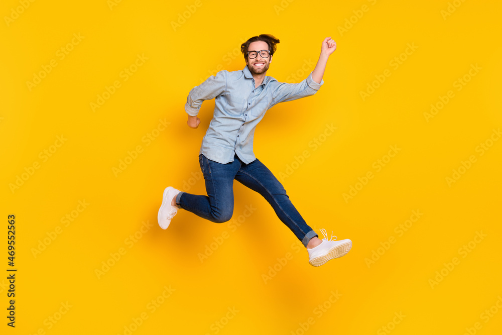 Full size profile side photo of young man happy positive smile have fun jump go walk isolated over yellow color background