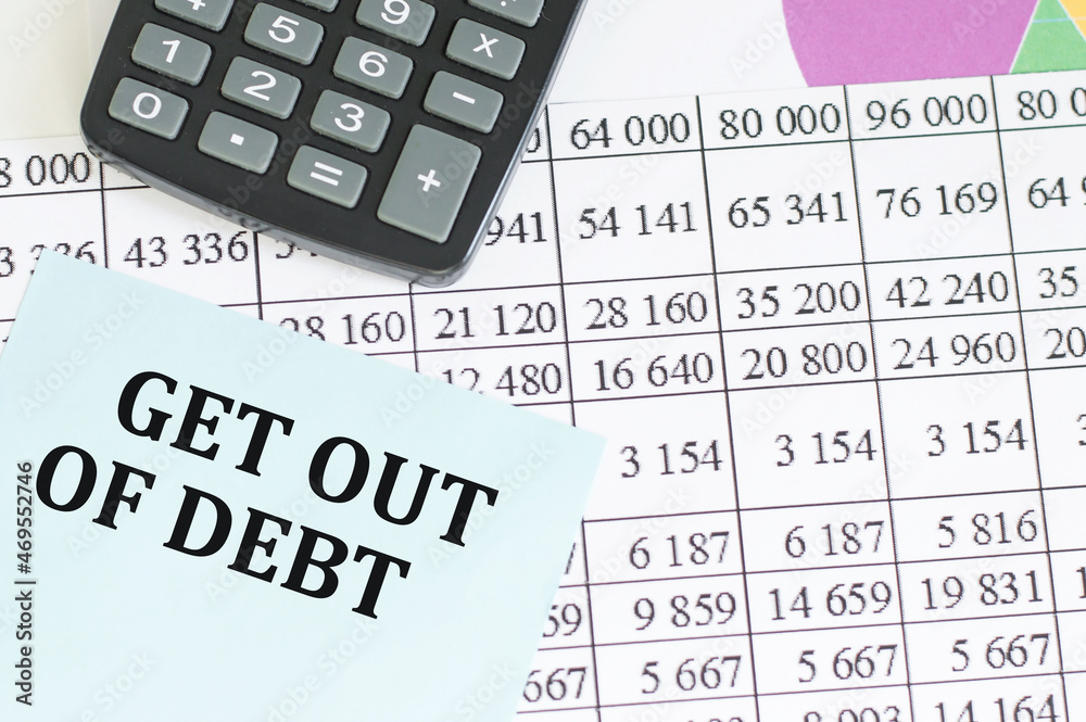 card with text get out of debt and calculator on office desk