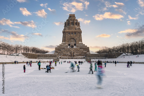Photography People playing ice hockey and skating on ice in front of the Monument to the Bat