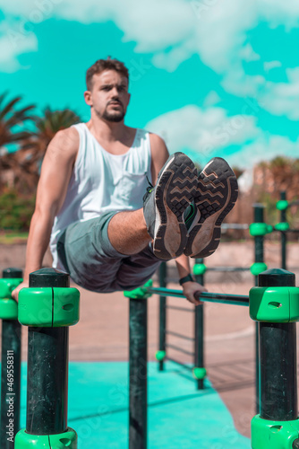 Fototapeta Naklejka Na Ścianę i Meble -  Young sportsman is training calisthenics on the sports ground outdoor. Healty lifestyle