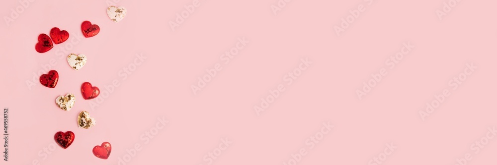 Pink background with copy space and white end red glossy hearts on it.Greeting card.Large banner.