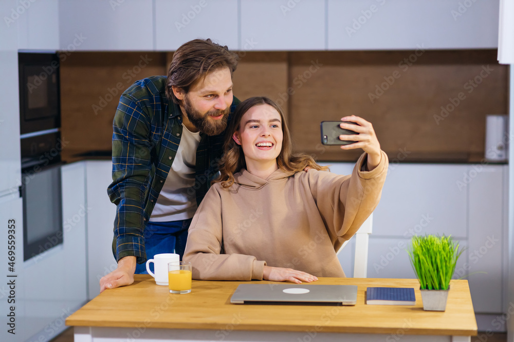 Fototapeta premium A young couple, at home in the kitchen, contacted their parents