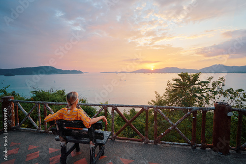 Traveling by Thailand. Young woman enjoying wonderful sunset on Phuket island view point.